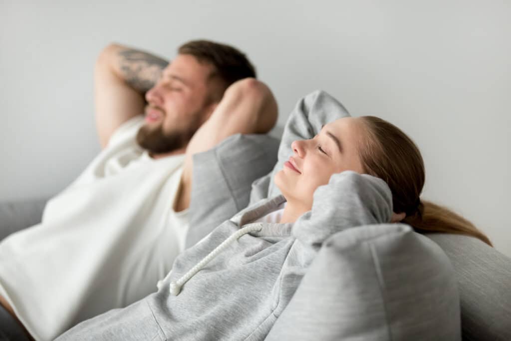 couple resting on sofa